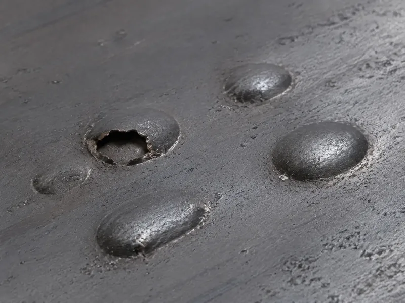Photograph of blister defects on hot-rolled steel strip surface showing circular and oval bulges