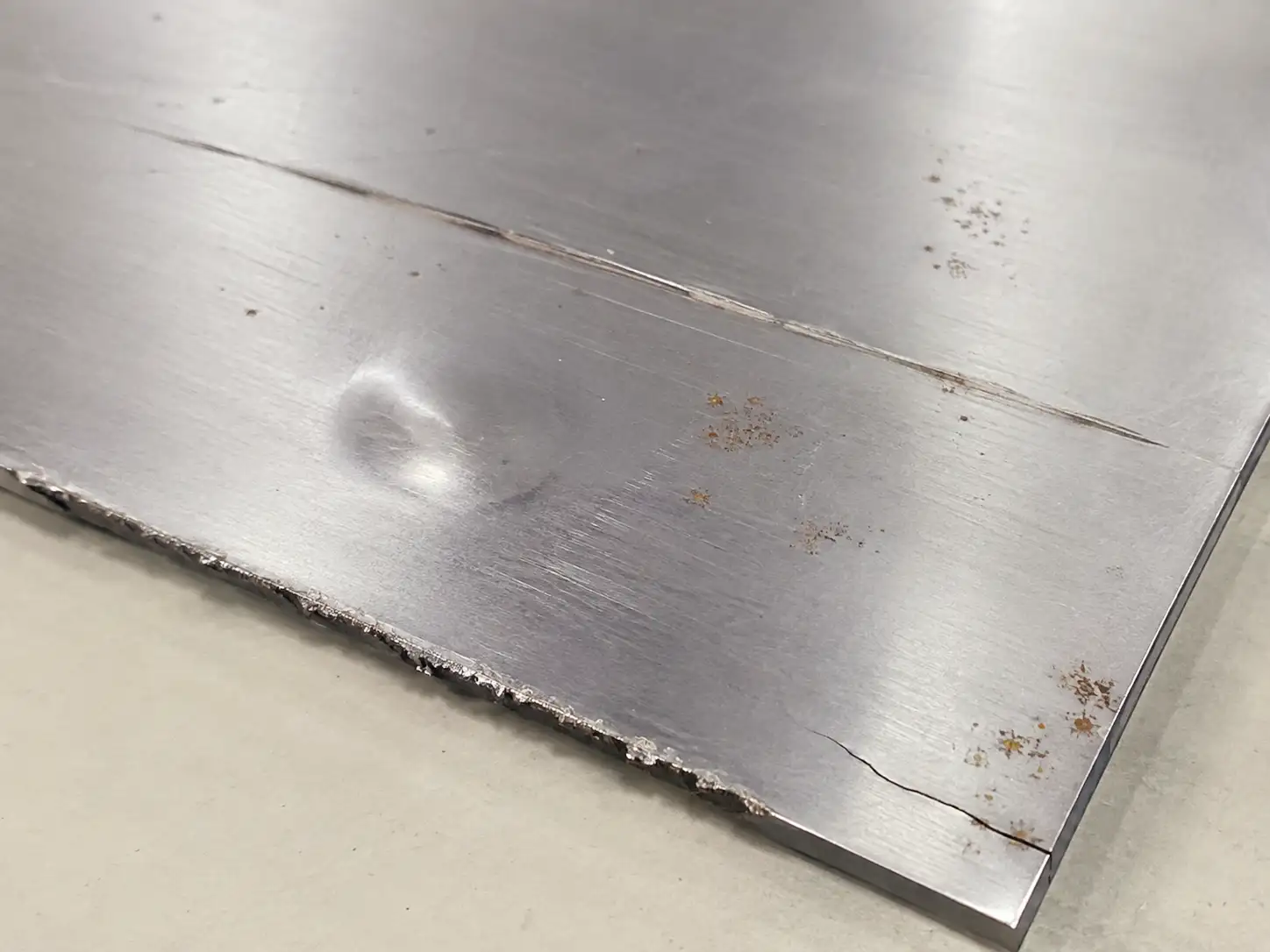 Non-Permissible Surface Defects on Cold-Rolled Steel Cold-rolled carbon steel sheet showing deep scratches, dents, edge burrs and rust defects