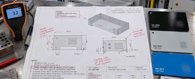 Engineer reviewing powder coating specifications on sheet metal drawing with coating thickness gauge and test samples
